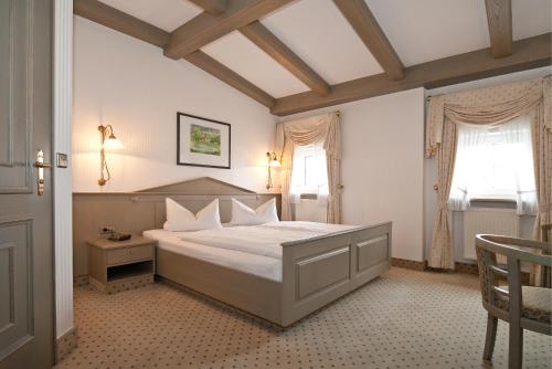 ein Schlafzimmer mit einem großen Bett und zwei Fenstern in der Unterkunft Hotel DREI SCHWANEN - Ristorante Due Fratelli in Hohenstein-Ernstthal