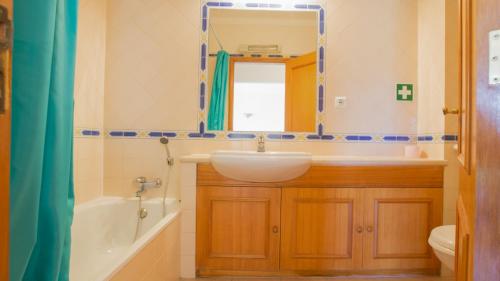 a bathroom with a sink and a mirror at Apartamentos Quinta da Praia in Alvor