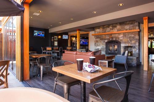 a restaurant with tables and chairs and a fireplace at The Lodge at Arrow Lakes in Nakusp