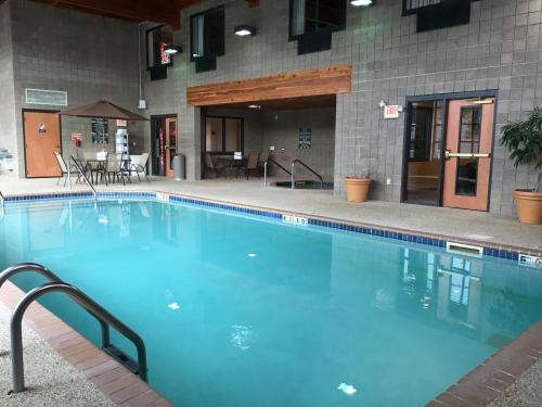 a large blue swimming pool in front of a building at Wingate by Wyndham Coon Rapids in Coon Rapids