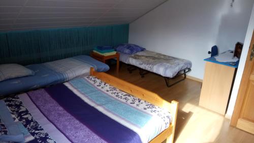 SelonnetにあるLes Nids de Mesangesのベッド2台とテーブルが備わる小さな客室です。