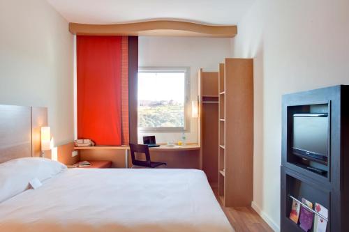 une chambre d'hôtel avec un lit et une télévision dans l'établissement Ibis Meknes, à Meknès