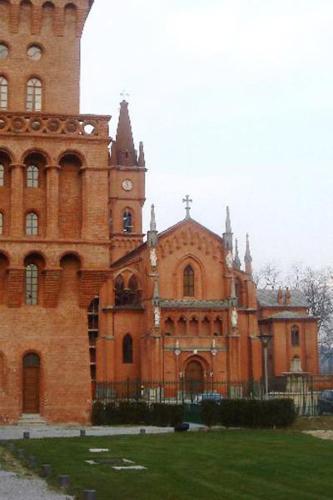 a large brick building with a clock tower at Il Mulino Di Geminella in Narzole