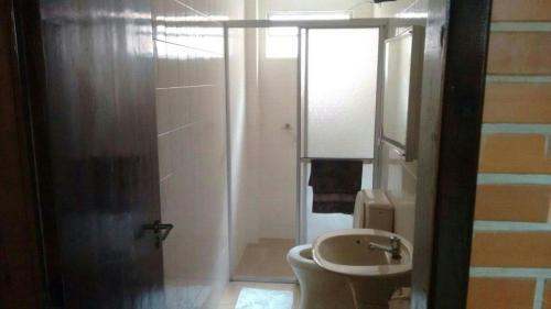 ein Bad mit einer Dusche, einem WC und einem Waschbecken in der Unterkunft Pousada Residencial Paineiras in Guaratuba