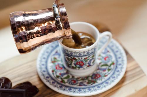 einen Kaffee, der auf einem Tisch in eine Tasse gegossen wird in der Unterkunft Erenler HoTeL & HosTeL in Istanbul
