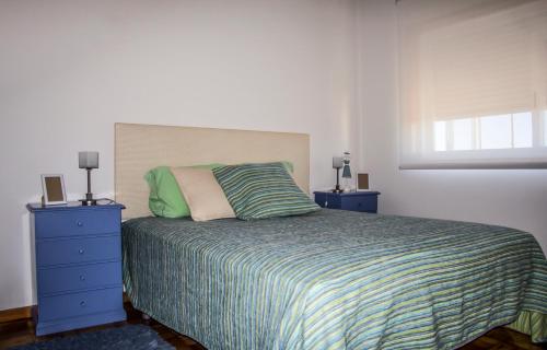 ein Schlafzimmer mit einem Bett und einer blauen Kommode in der Unterkunft Combatentes Apartment in Porto