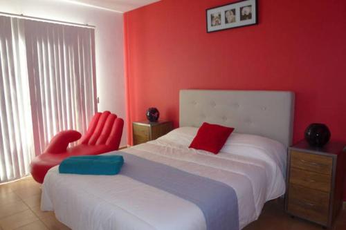 una camera con due sedie rosse e un letto di Villa Son Remei a Punta Prima