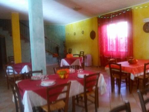 a dining room with tables and chairs with red table cloth at Agriturismo Lerno in Pattada