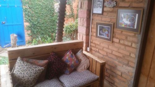 a window seat with pillows on a brick wall at hostelvi guesthouse in Lençóis