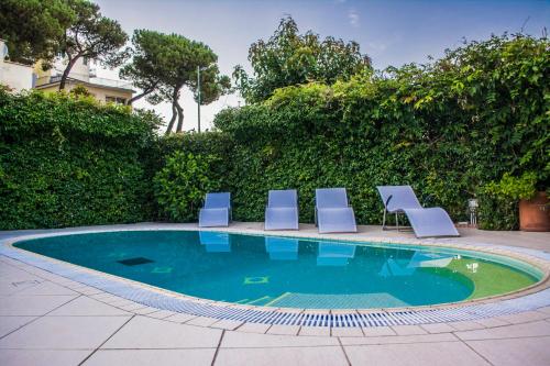 a pool with three lounge chairs and a swimming pool at VILLA MARYLU' in Ischia Town