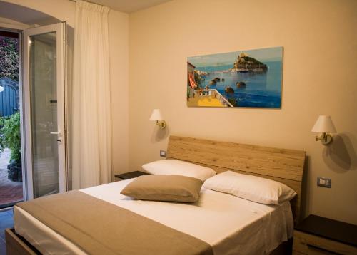 a bedroom with a bed and a painting on the wall at VILLA MARYLU' in Ischia Town