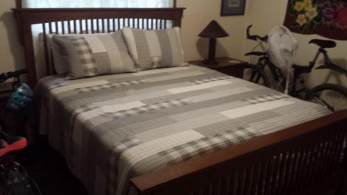 una cama en un dormitorio con una bicicleta estacionada al lado en Robbrecht Troost Pottery, en Pahoa