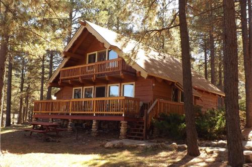 a log cabin in the woods with a picnic table in front at Arizona Mountain Inn & Cabins in Flagstaff