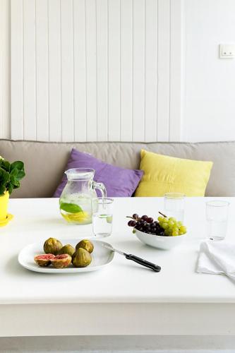 a white coffee table with a plate of food on it at Kapetan Tasos Suites in Pollonia