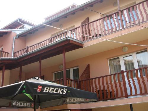 a beets umbrella sitting in front of a building at Family Hotel Miglena in Govedartsi
