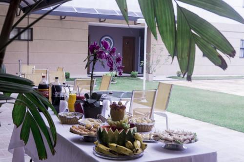a table with plates of food on top at Hotel Santos Dumont in Goiânia