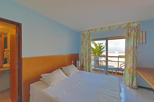 um quarto com uma cama e uma varanda em Vip Praia Hotel em Natal