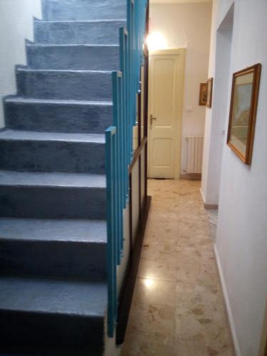 a hallway with blue stairs in a house at Affitti Brevi Mamoiada Centro in Mamoiada