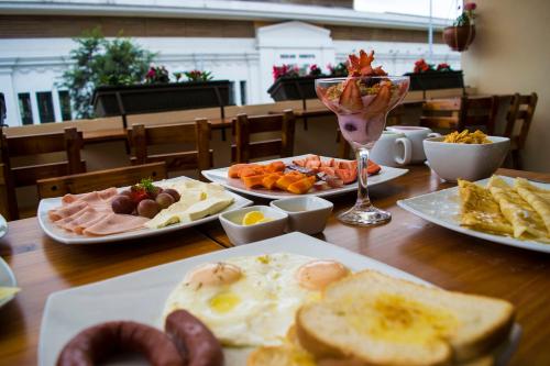 a table with plates of breakfast foods on it at Hotel Boutique Castilla de Leòn in Cuenca