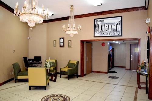 a lobby with chandeliers and chairs and a waiting room at Super 8 by Wyndham Homewood Birmingham Area in Birmingham