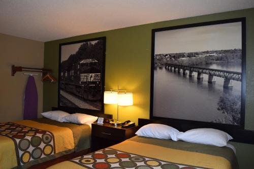 a hotel room with two beds and a large picture on the wall at Super 8 by Wyndham Homewood Birmingham Area in Birmingham