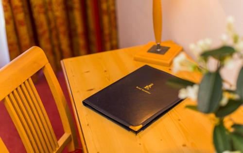 a wooden table with a book on top of it at Hotel Excelsior in Zermatt