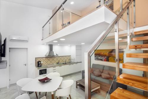 a kitchen and dining room with a white table and chairs at Maredimo Village Porto Casa 1 in Porto