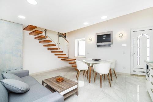 a living room with a staircase and a table at Maredimo Village Porto Casa 1 in Porto