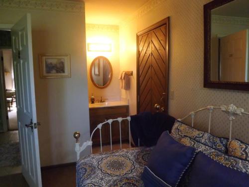 a bedroom with a bed and a bathroom with a mirror at Arizona Mountain Inn & Cabins in Flagstaff