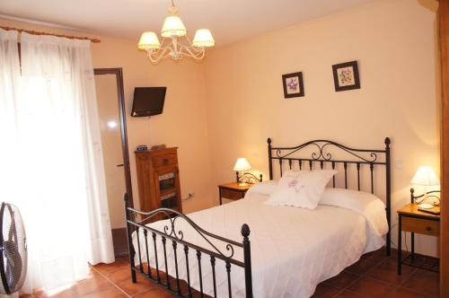 a bedroom with a bed and a chandelier at Casa Rural Blas in Brihuega