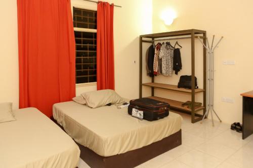 um quarto com duas camas e uma prateleira com uma mala em Connect Africa Apartments em Acra