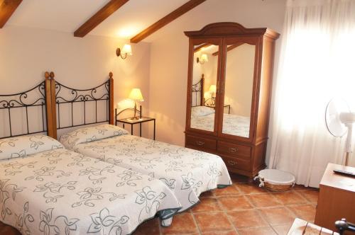 a bedroom with two beds and a large mirror at Casa Rural Blas in Brihuega