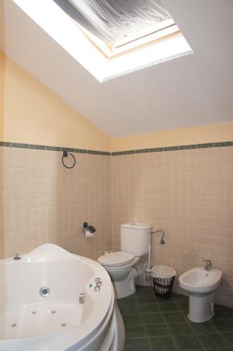a bathroom with a tub and a toilet and a skylight at Casa Rural Blas in Brihuega