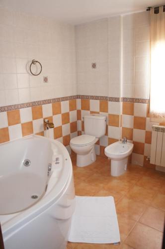 a bathroom with a tub and a toilet and a bidet at Casa Rural Blas in Brihuega