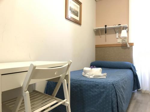 a room with a table and a chair with a cake on it at Hostal El Pilar in Madrid
