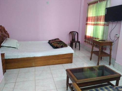 ein Schlafzimmer mit Bett, Fernseher und Tisch in der Unterkunft Hotel Green Castle in Rangamati