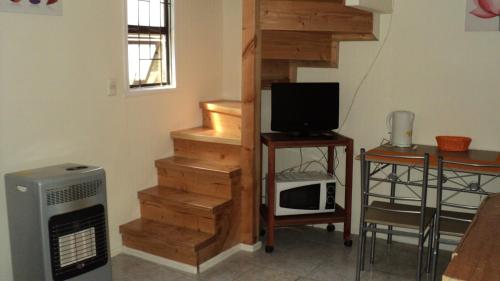 um quarto com uma escada, uma televisão e um micro-ondas em Departamentos Arlenne II em Valdivia