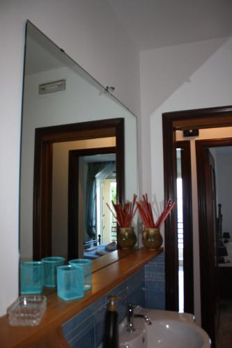 ein Bad mit einem Waschbecken und einem Spiegel in der Unterkunft Patrancarro Home in Letojanni
