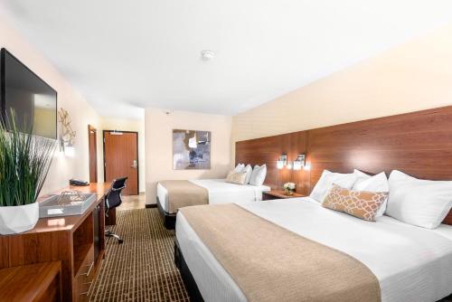 a hotel room with two beds and a desk at Ellis Island Hotel Casino & Brewery in Las Vegas