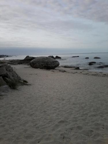 a sandy beach with rocks and the ocean at les roches du Cabellou 150M de la mer in Concarneau