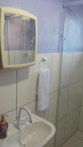 une salle de bain avec un lavabo et un miroir dans l'établissement Sunshine, à Gramado