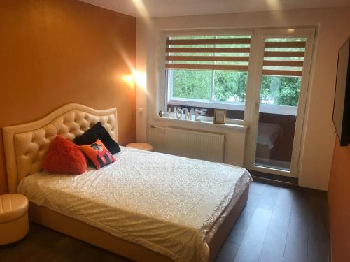 ein Schlafzimmer mit einem Bett mit zwei Kissen und einem Fenster in der Unterkunft Trumpalaikė buto nuoma Rokiškyje su jacuzzi in Rokiškis