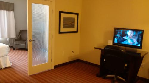 
a living room with a television and a couch at Sigma Inn & Suites Hudson's Hope in Hudson Hope
