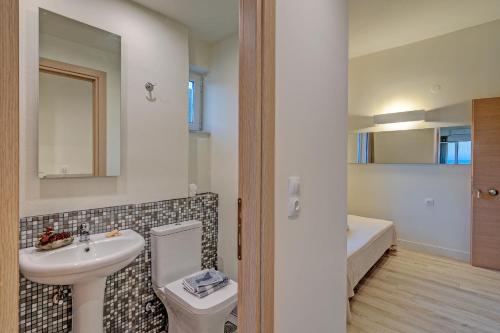 uma casa de banho com um lavatório, um WC e uma banheira em Sofia's Lovely Rooms em Chora Sfakion