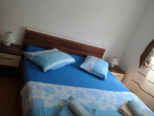 ein Schlafzimmer mit einem blauen Bett und zwei Kissen in der Unterkunft Apartment Andjel in Poreč