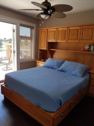 a bedroom with a bed with a blue comforter at Kaslo Bay Condominium in Kaslo