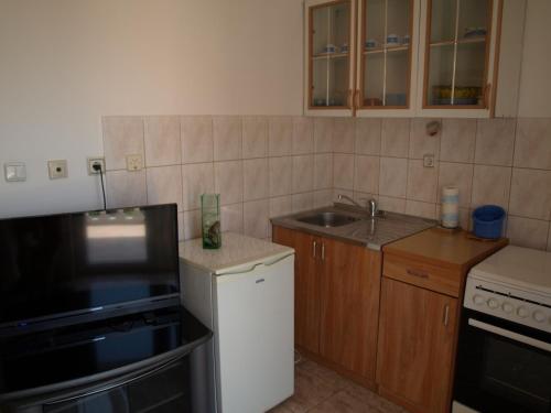 a small kitchen with a sink and a stove at Apartmani Adriana1979 in Vodice