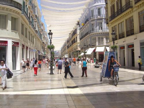 a group of people walking down a city street at Hostal Larios in Málaga