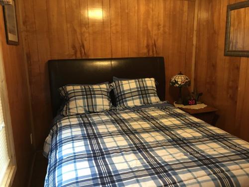 a bed with plaid sheets and pillows in a room at Big Cypress in Lake Panasoffkee
