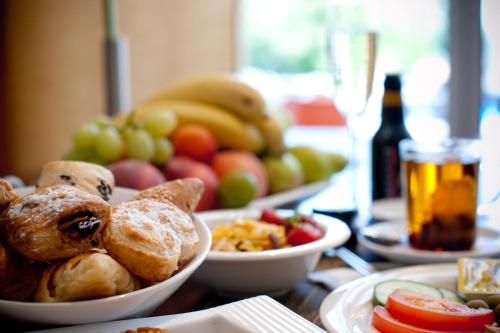 a table topped with bowls of food and fruit at Mercure Aachen Europaplatz in Aachen